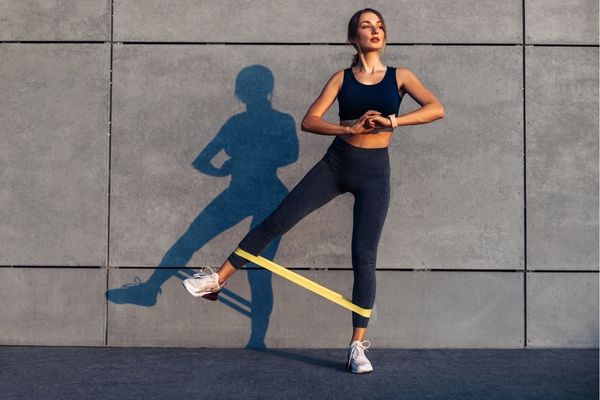 Woman doing a leg lift with resistance bands.