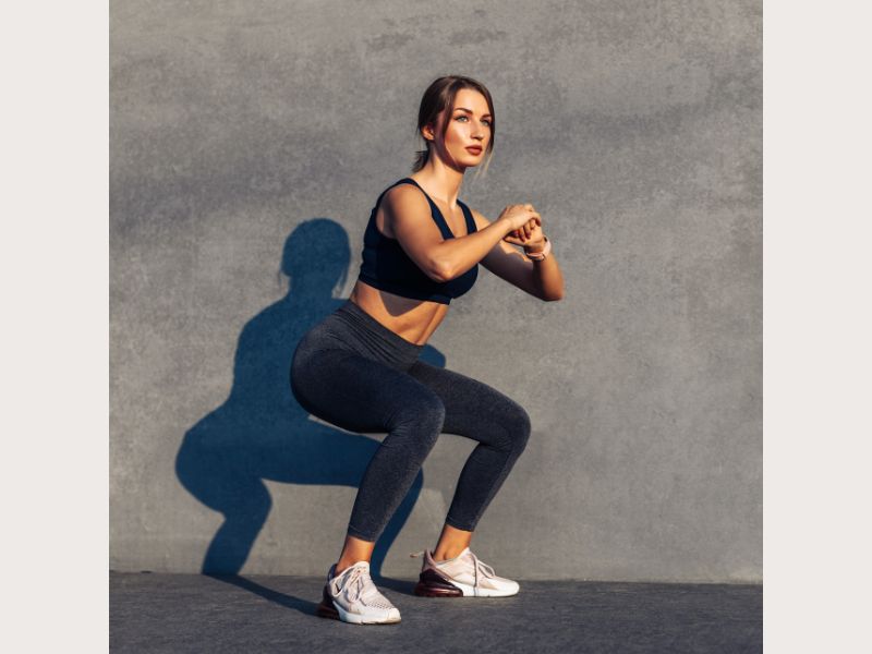 Woman doing a basic bodyweight squat.